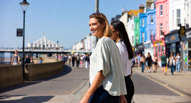 Adult language study holidays in England Brighton with LISA! – promenade, city and seaside Female participants walking along the promenade in Brighton with colourful houses during a LISA! language study holiday in England