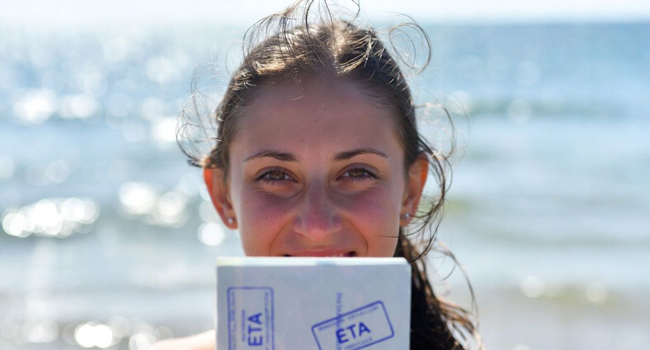 Adult language study holidays in England Brighton with LISA! – entry requirements, visa and ETA Female participant holding ETA entry document on the beach in Brighton during a LISA! language study holiday in England