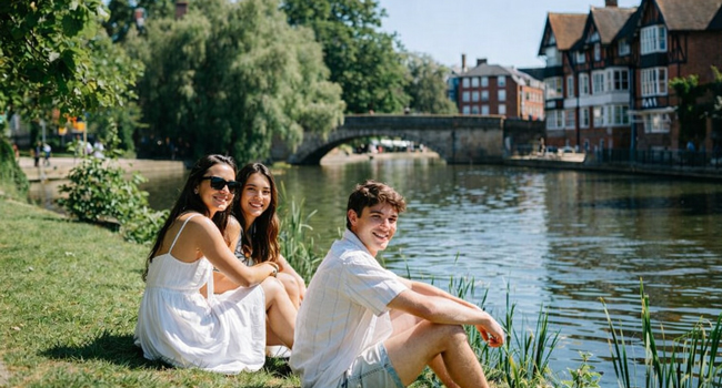  Adult participants of a LISA! language study holiday in Cambridge City England sitting by the river enjoying the sun and free time