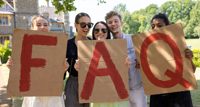  Adult participants of a LISA! language study holiday in Cambridge City England holding FAQ letters in a park