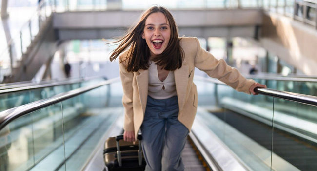Educational leave Québec Canada with LISA! – learning French and travelling with ease Young adult with suitcase at the airport during a LISA! educational leave language study holiday excited about travelling to Québec