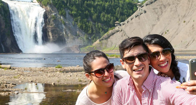 Educational leave Québec Canada with LISA! – learning French and enjoying natural experiences Adults taking a selfie in front of a waterfall in Québec during a LISA! educational leave language study holiday enjoying nature and leisure activities