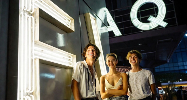 Language study holidays Tokyo Chiyoda with LISA! – nightlife, city and unforgettable experiences Young adults standing in front of a glowing FAQ sign in Tokyo during a LISA! language study holiday enjoying the city nightlife