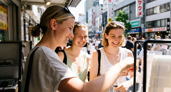 Language study holidays Tokyo Chiyoda with LISA! – street food, shopping and authentic experiences in Japan Adults buying street food in Tokyo during a LISA! language study holiday discovering local specialities and culture