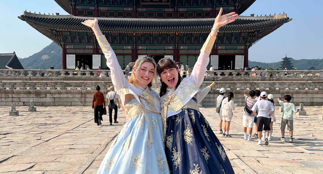 Language study holidays Seoul Hongdae with LISA! – culture, tradition and unforgettable experiences in Korea Adults wearing traditional Korean clothing in front of a temple in Seoul during a LISA! language study holiday experiencing culture
