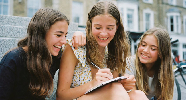 Student language study holidays in England Brighton with LISA! – learning together and making friends Three female students studying together during a LISA! language study holiday for students in England Brighton in the city