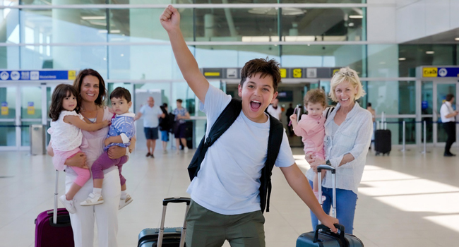 Student arriving at the airport with raised fist excited for a LISA! language study holiday for students in England Brighton