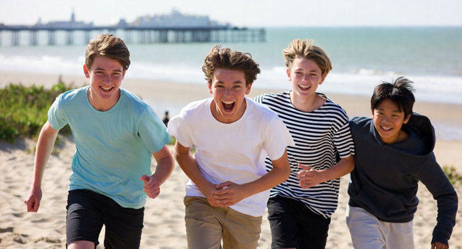 Four students running on the beach in Brighton during a LISA! language study holiday for students in England
