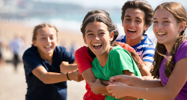 Group of students in Eastbourne England during a LISA! language study holiday playing together on the beach and feeling safely supervised