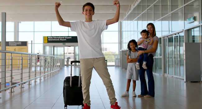 Arrival in Malta for a student English language study holiday with LISA! Student arrival in Malta for a language study holiday with raised arms in a victory pose with host parents in the background