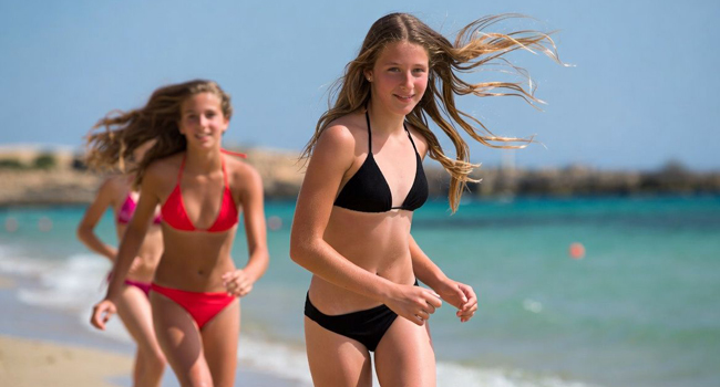 Student language study holidays in Malta with LISA! – girls on the beach in summer Two female students running on the beach in Malta during a LISA! language study holiday for students