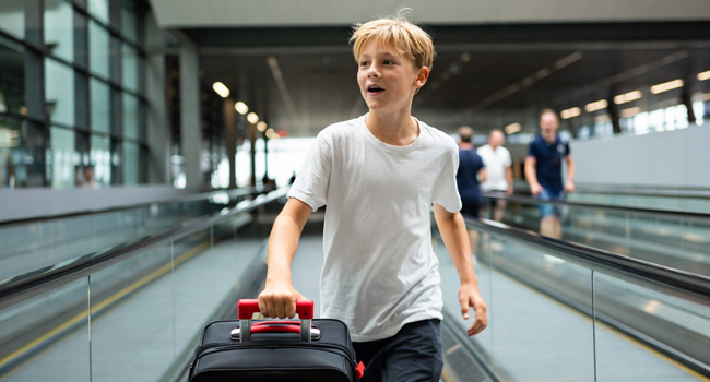 A boy arriving on an airport moving walkway for a student language study trip to Málaga represents travelling to a LISA! language study holiday for students in Málaga, Spain.