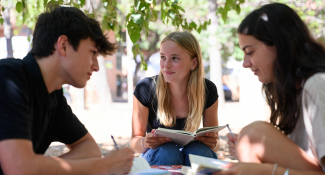 Three students in a garden in Málaga learning Spanish represent Spanish courses in Málaga with LISA!.