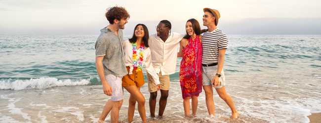 Spass am Strand bei Sonne und Meer in Kapstadt Mehrere Personen stehen im Wasser am Meer bei einer LISA! Sprachreise in Kapstadt
