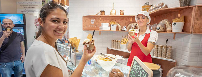 Bestes gelato mitten in Florenz bei einer Sprachreise Italienisch Eine Frau kauft in einer Gelateria in Florenz ein Eis