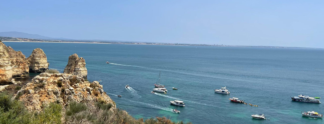Mehrere Boote kreuzen auf dem Meer vor der Küste von Faro in Portugal