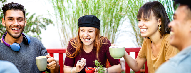 Neue Freunde bei einer LISA! Sprachreise in Lissabon in Portugal Vier freunde trinken Kaffee bei einer lustigen Unterhaltung bei einer Portugiesisch-Sprachreise in Lissabon