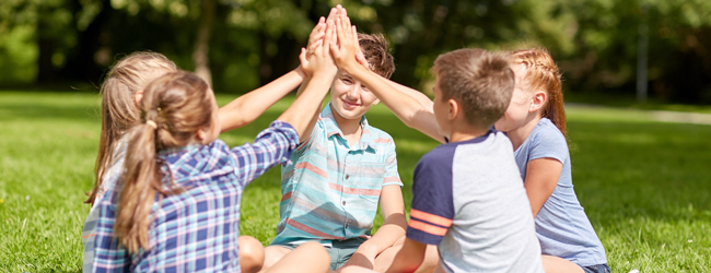 Gemeinsamer Spass und Spiel bei einer Sprachreise in Marlborough für Schüler Kinder sitzen im Kreis und klatschen mit den Händen bei einer LISA! Schülersprachreise in Marlborough