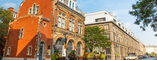 Historisches rotes Gebäude mit Pflanzen davor in Montreal, Kanada